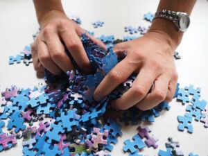 two hands holding puzzle pieces